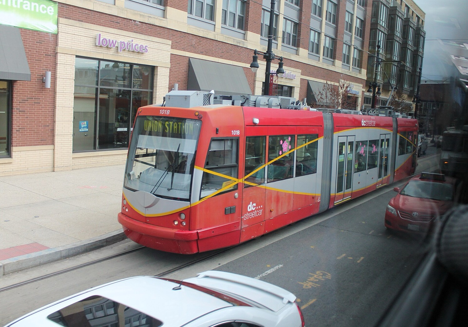 A red DC Streetcar bound for Union Station runs along H Street NE.